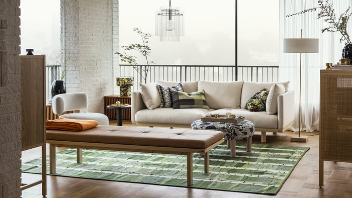 Sala de estar cálida con sofá beige y lámpara nórdica.