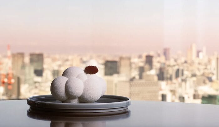 Postre escultórico en blanco inspirado en Pantone Cloud Dancer con vistas urbanas desde Mandarin Oriental.